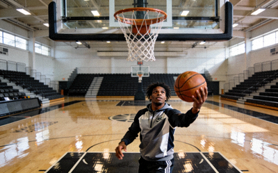 篮球运动员在赛前热身训练中投篮，背景是空旷的体育馆